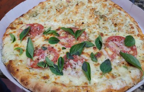 Foto de uma pizza meia napolitana e meia frango com catupiry.